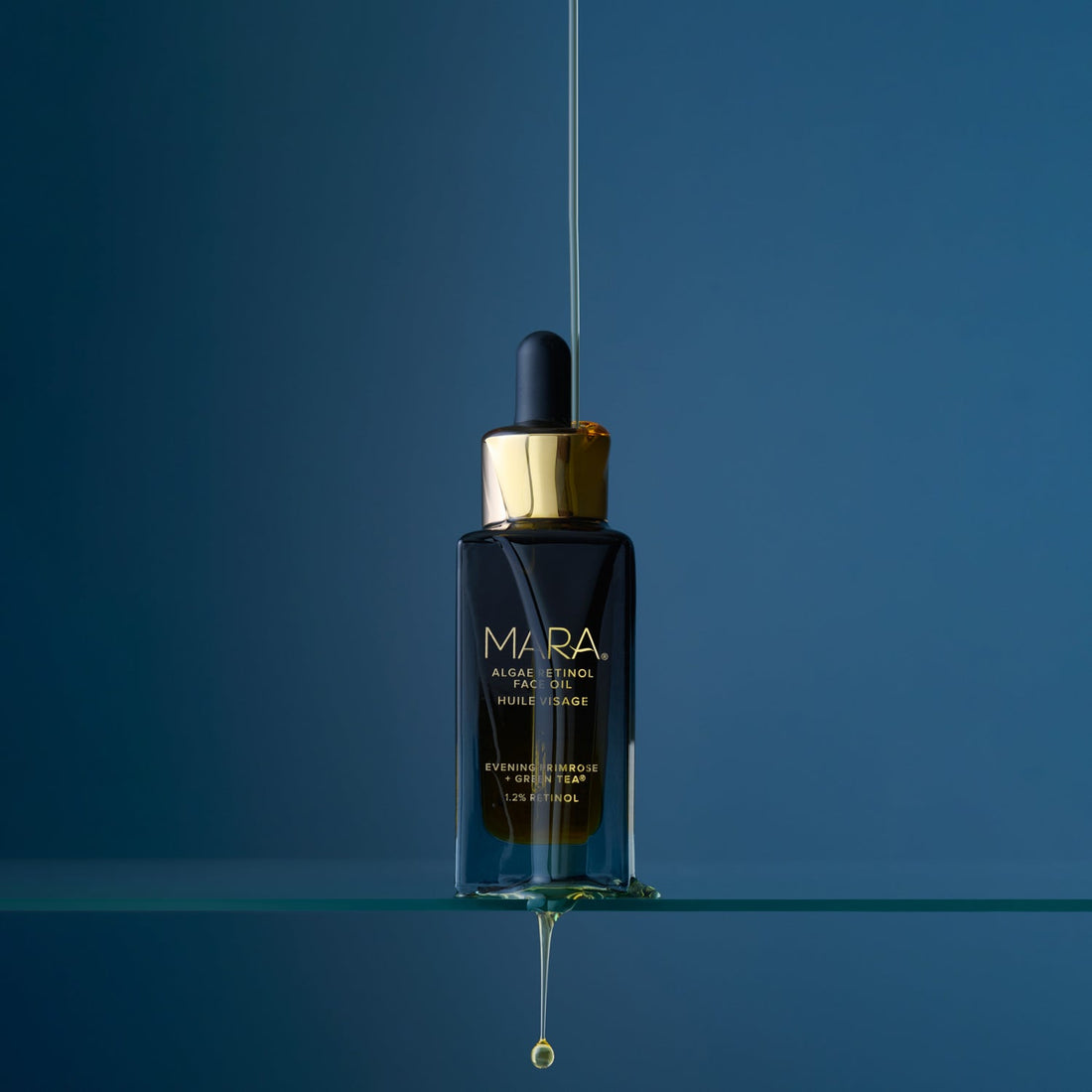 Algae Retinol Face Oil on glass shelf with dark blue background