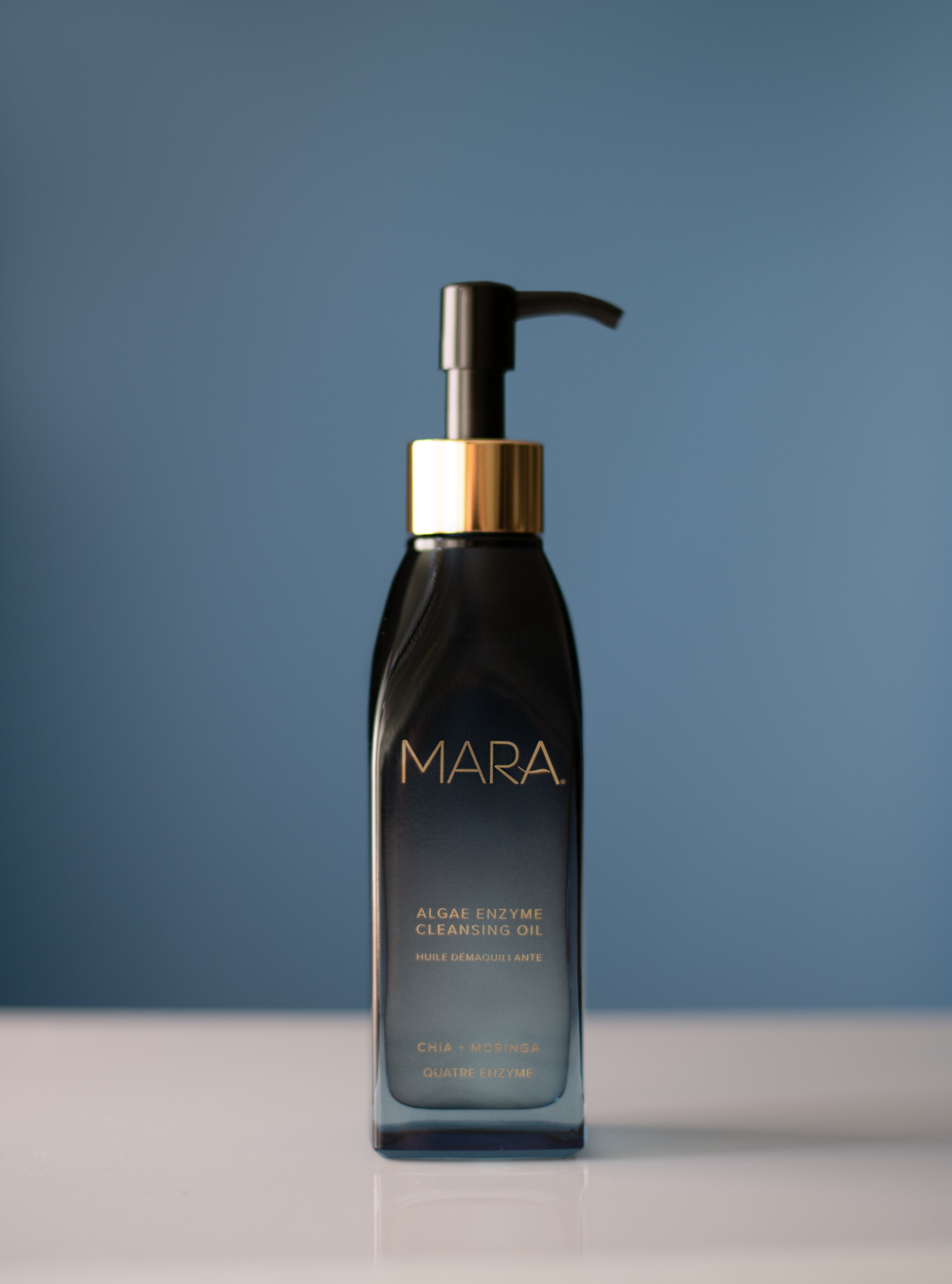 Black bottle with pump and gold cap labeled 'MARA' on a blue background