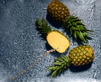 Three pineapples on a textured gray surface