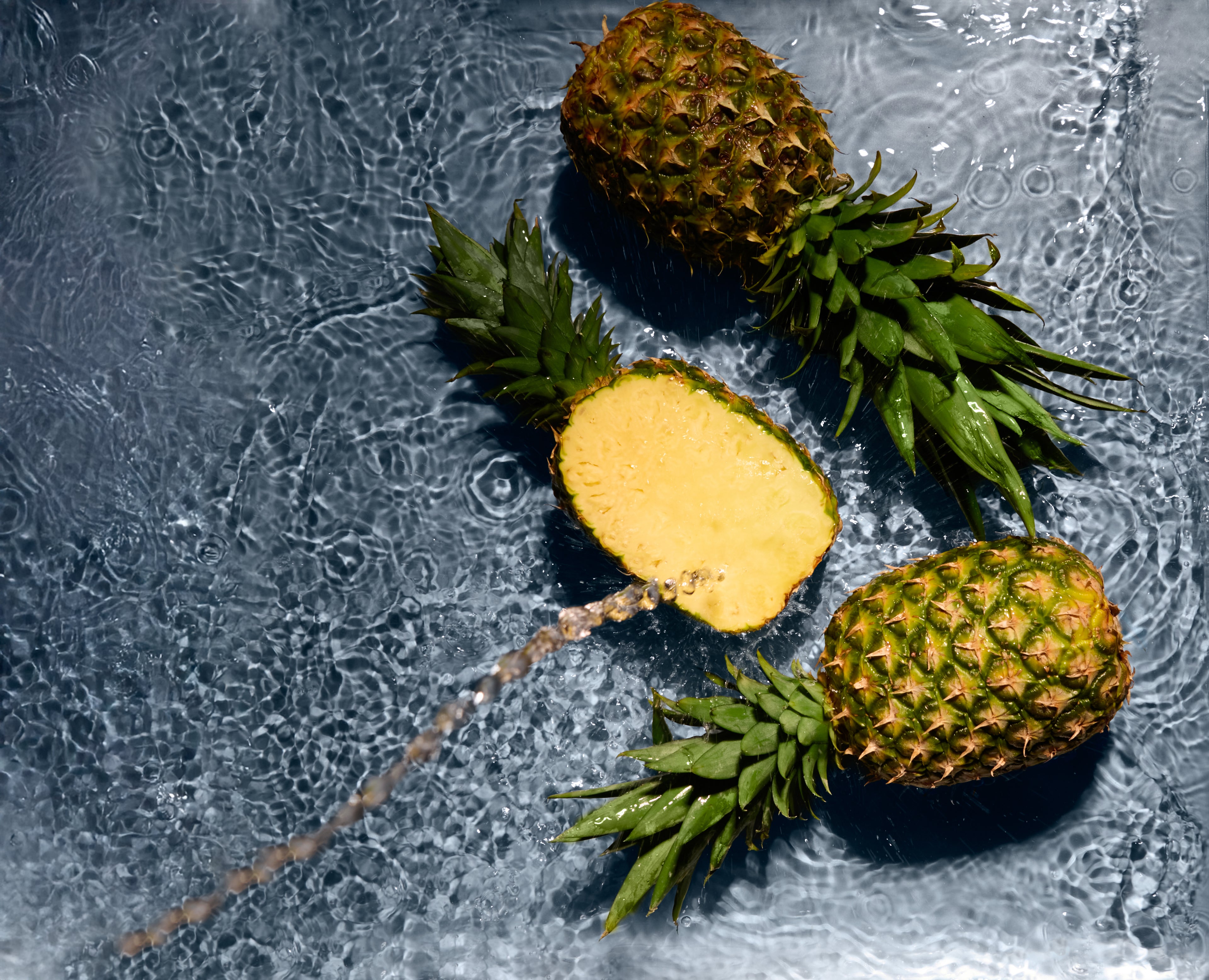 Three pineapples on a textured gray surface