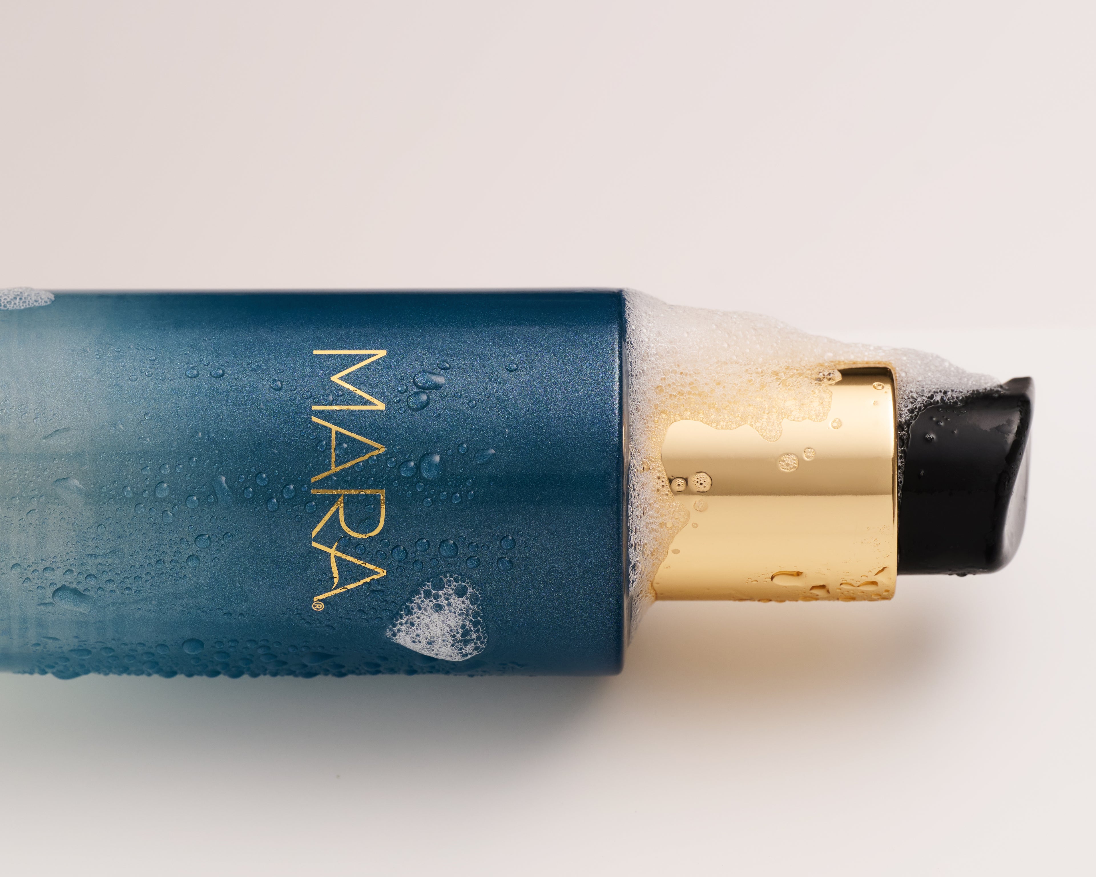 Mara Aura cleanser on its side with bubbles coming out
