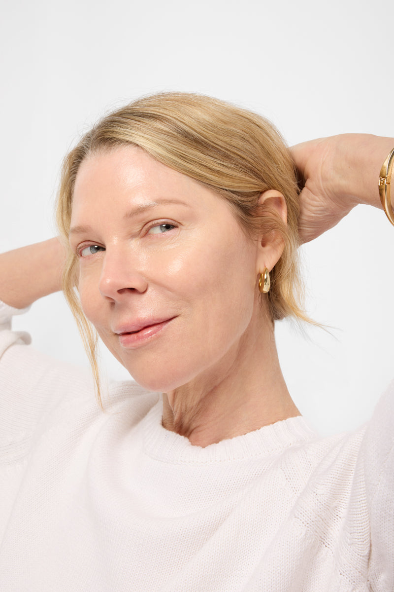 Model looking to side with arms up