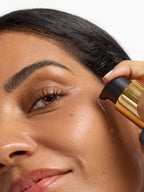 Person applying Aura Cleanse Foaming Gel Cleanser to face