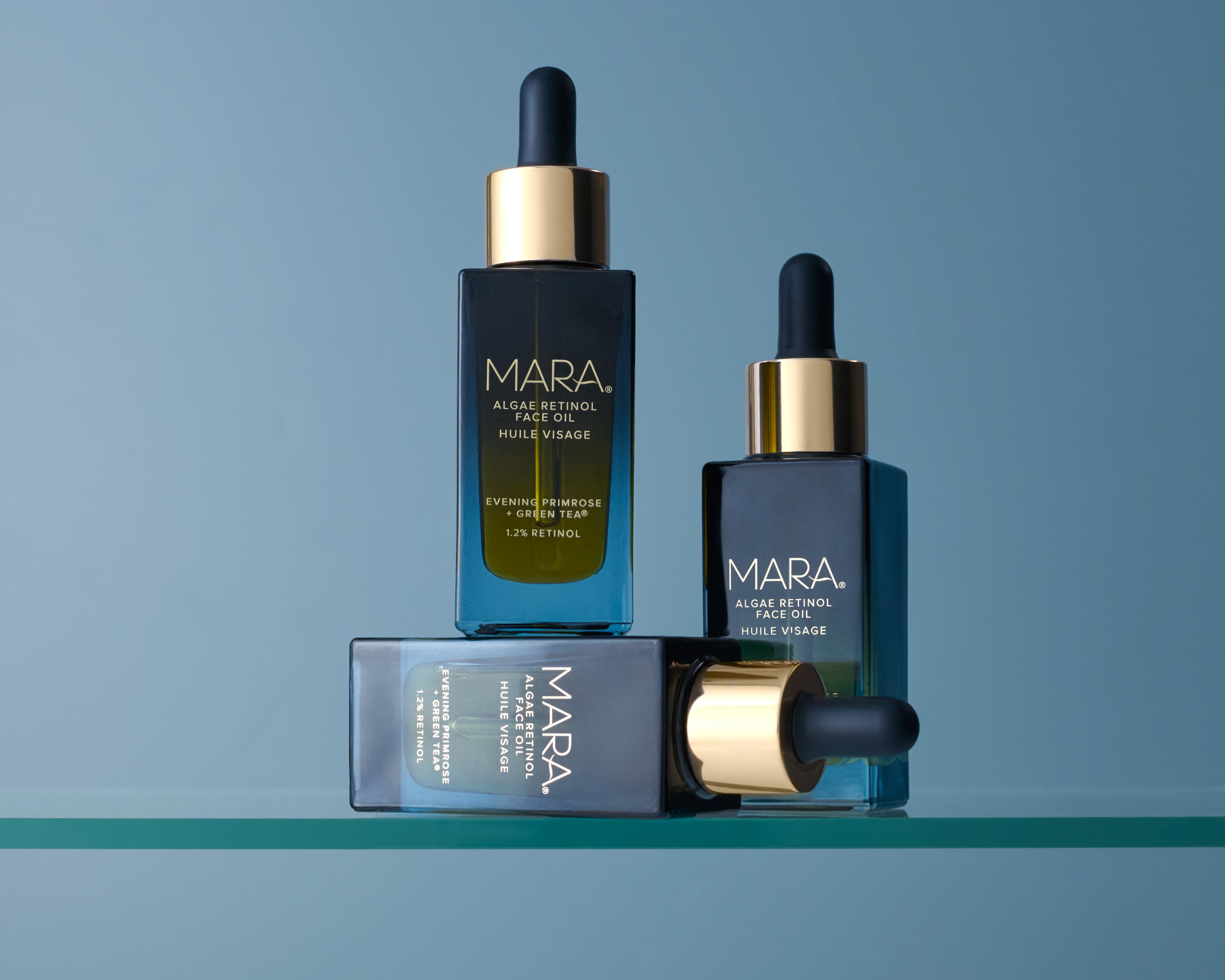 Three bottles of Algae Retinol Face Oil on a blue background