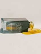 Algae Retinol Face Oil spilling out on a beige background