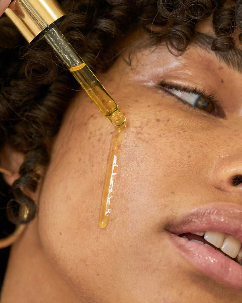 Model putting Algae Retinol Face Oil on face with dropper | Mara Beauty