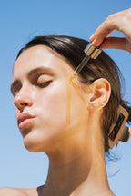 Model applying algae retinol face oil to skin