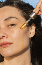 model applying algae retinol face oil to skin