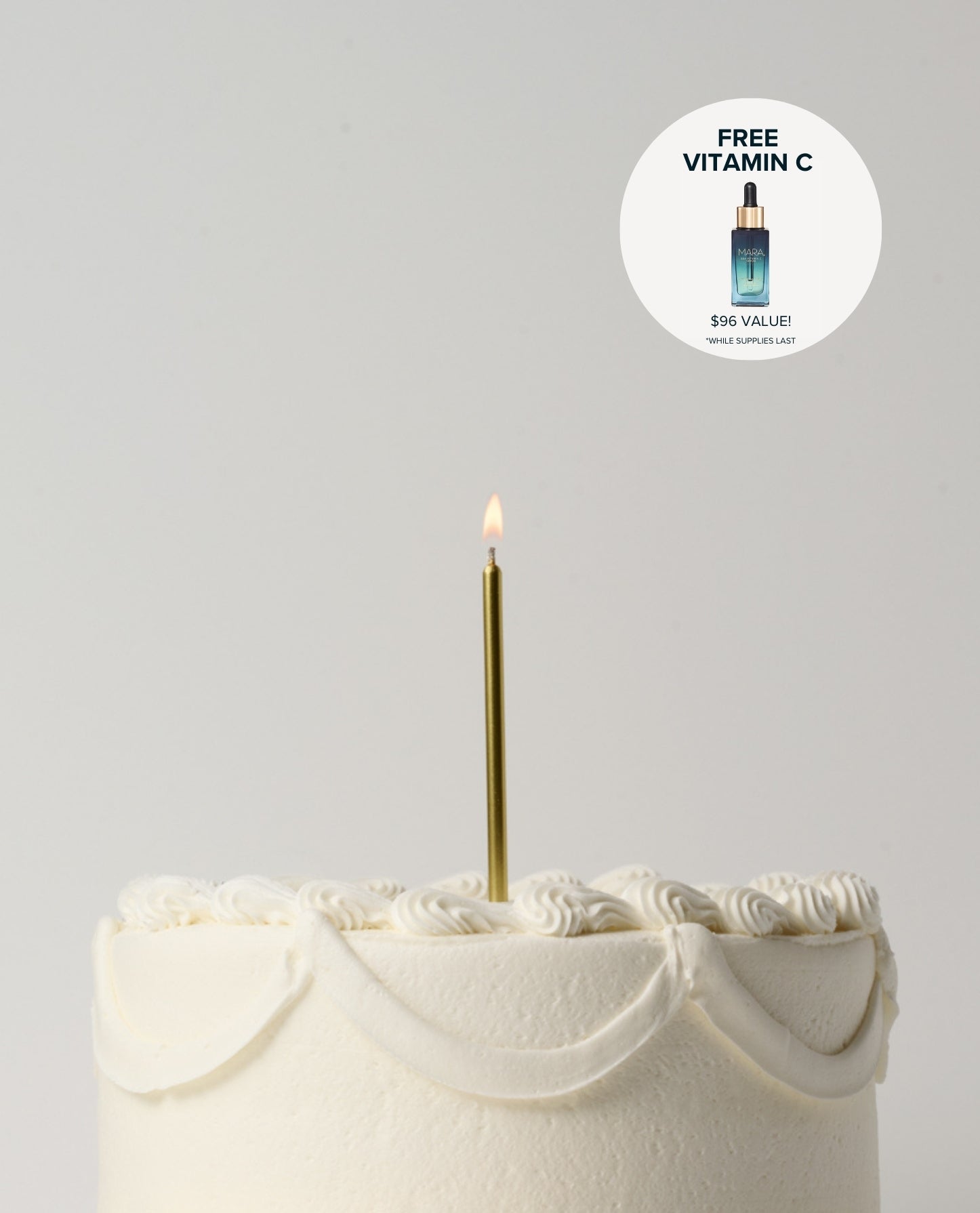 White cake with a gold candle on a gray background, featuring a free vitamin C offer.