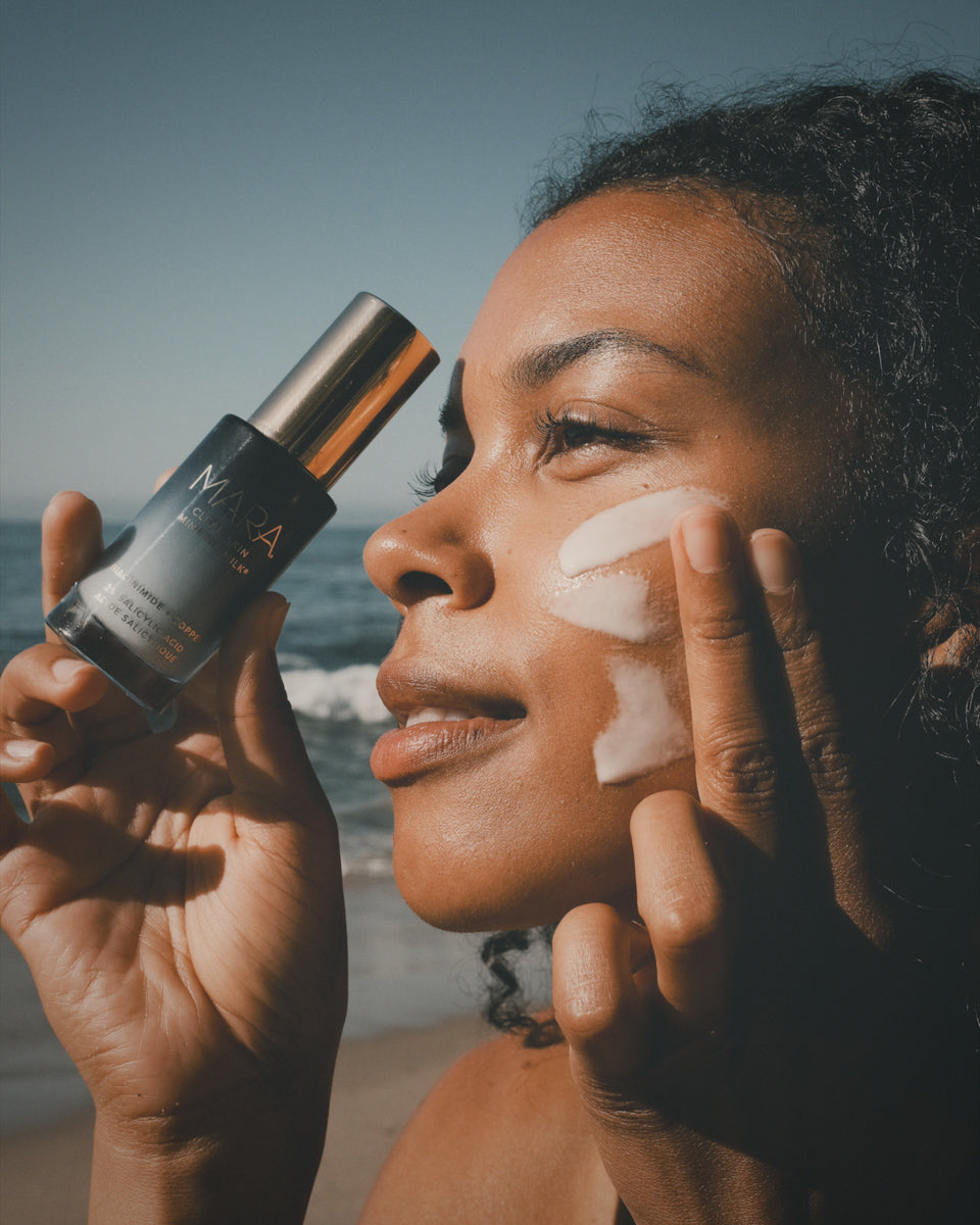 Model putting Clear Skin Mineral Milk on face