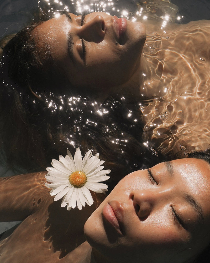 Models floating in water with flower