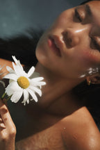 Model floating in water holding flower