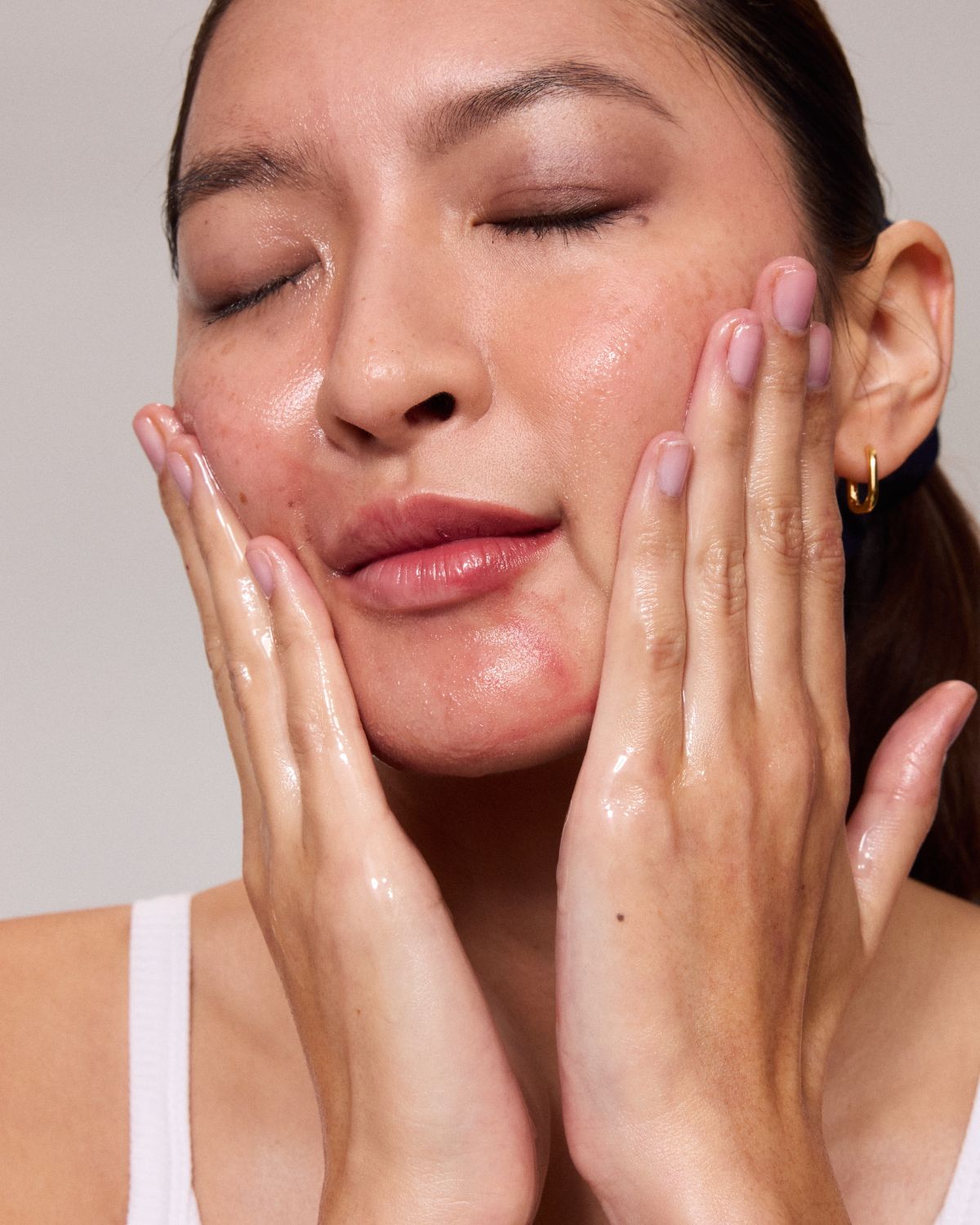 Model removing makeup with MARA Algae Enzyme Cleansing Oil