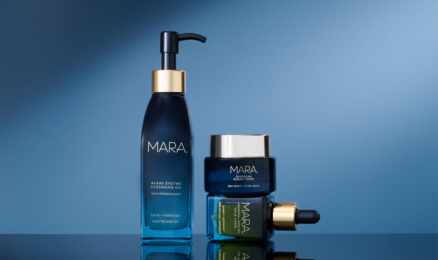 MARA Algae Enzyme Cleansing Oil, Universal Face Oil and SeaDream Creme on a reflective surface with a blue gradient background