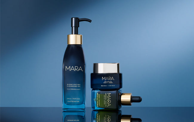 MARA Algae Enzyme Cleansing Oil, Universal Face Oil and SeaDream Creme on a reflective surface with a blue gradient background