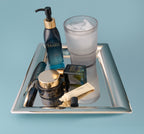 Cleansing Oil, SeaDream Algae Creme, Universal Face Oil and Sea Silk Lip Balm on a silver tray with a glass of water