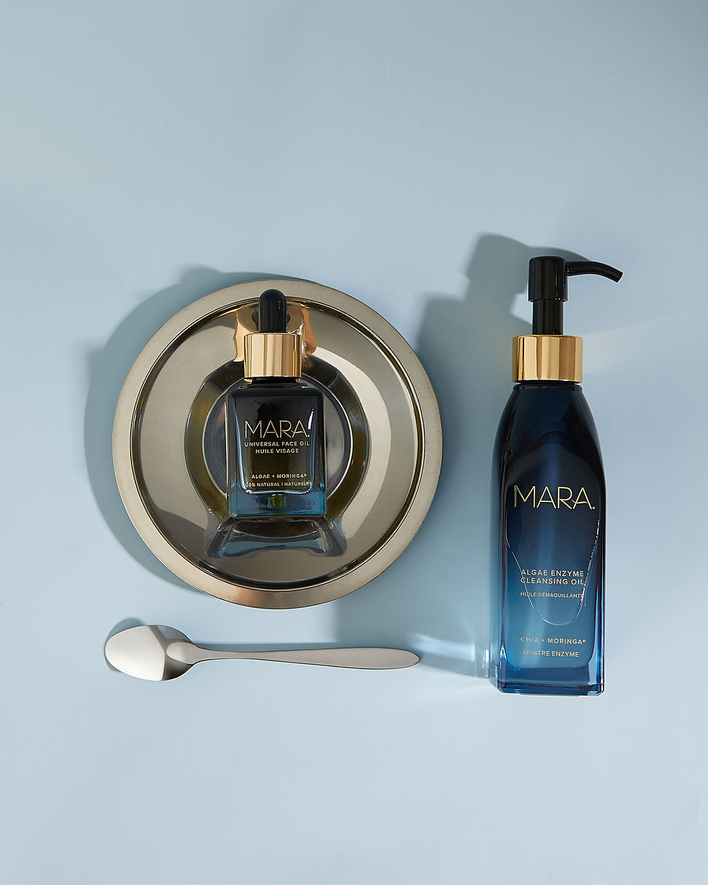 Cleansing Oil and Universal Oil on blue surface