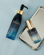 Cleansing Oil and Clear Skin Mineral Milk on silver tray on blue background