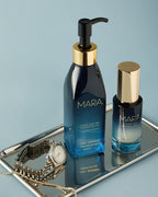Cleansing Oil, Clear Skin Mineral Milk, and watch on silver tray on blue background