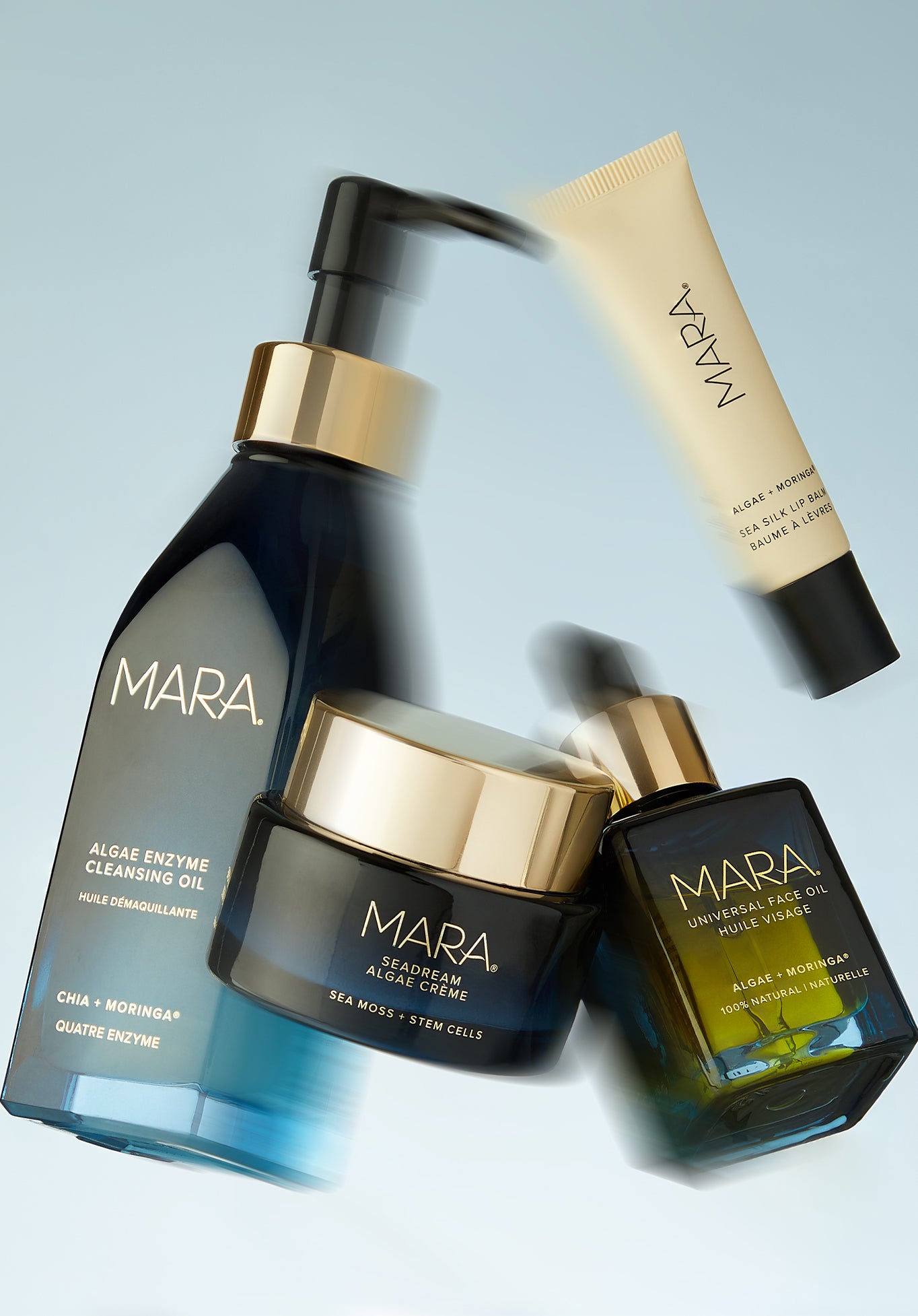 MARA Algae Enzyme Cleansing Oil, Universal Face Oil, SeaDream Creme, and Sea Silk Llip Balm floating on light blue background