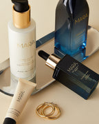 Cleansing Oil, Pearl Peptide, Vitamin C, and Lip Balm on silver tray on beige background