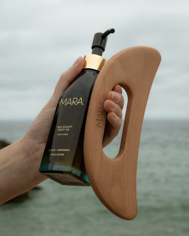 Hand holding Sea Sculpt Body Oil and Body Tool | Mara Beauty