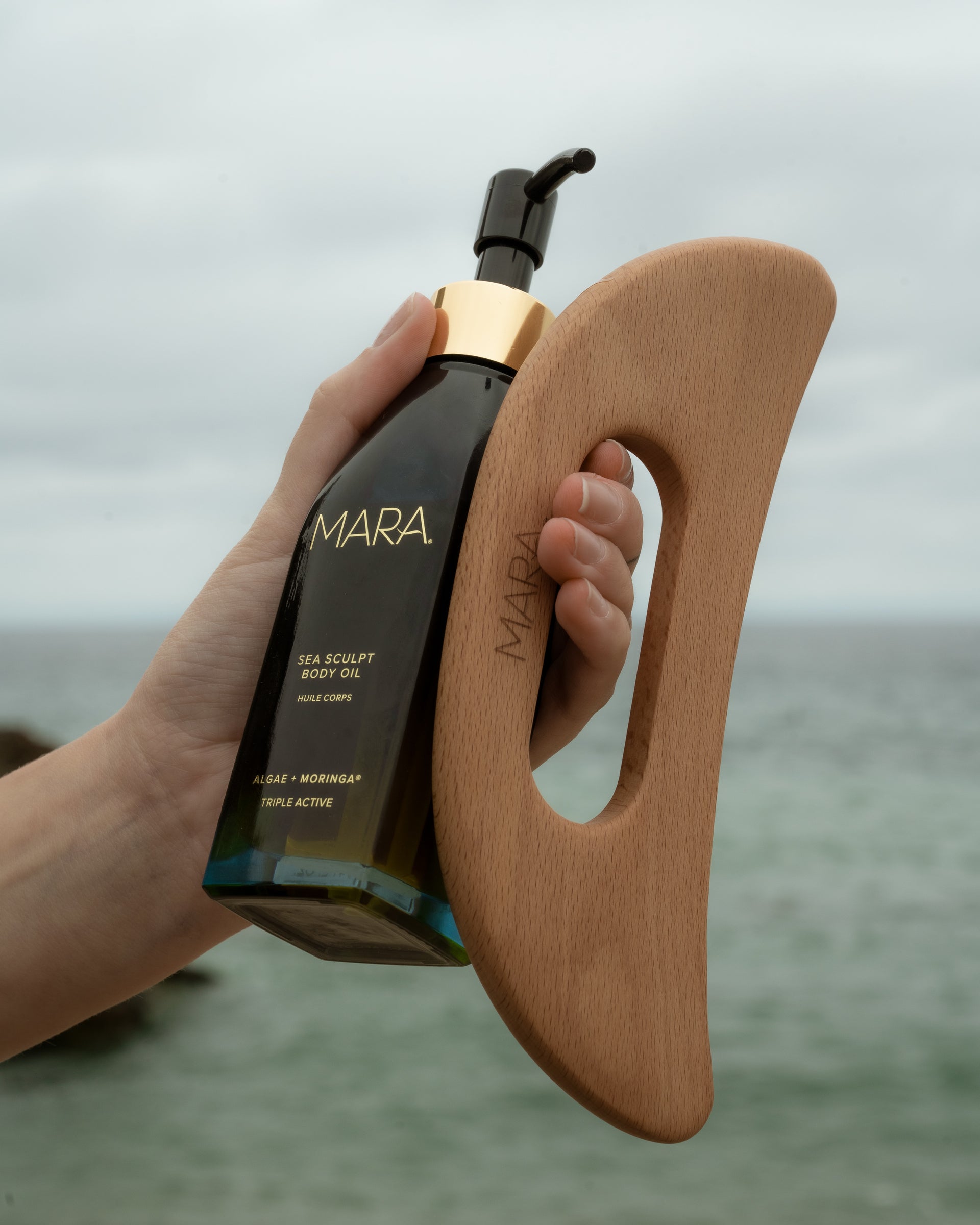 sea sculpt body oil and body tool in hand