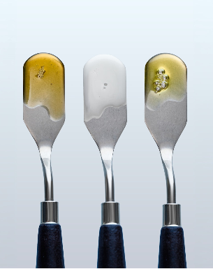 Three metal spatulas with dark blue handles are shown against a light gray gradient background with Sea Sculpt Body Oil, Pearl Peptide Glaze, Universal Face Oil