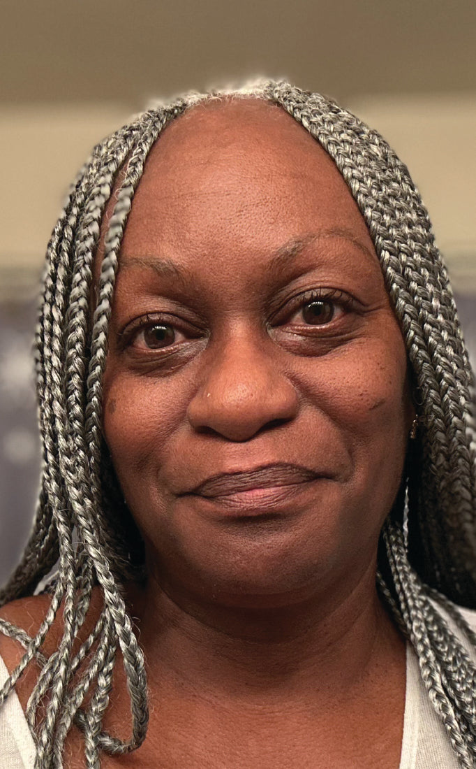 Woman with braided hair wearing a white top in an indoor setting