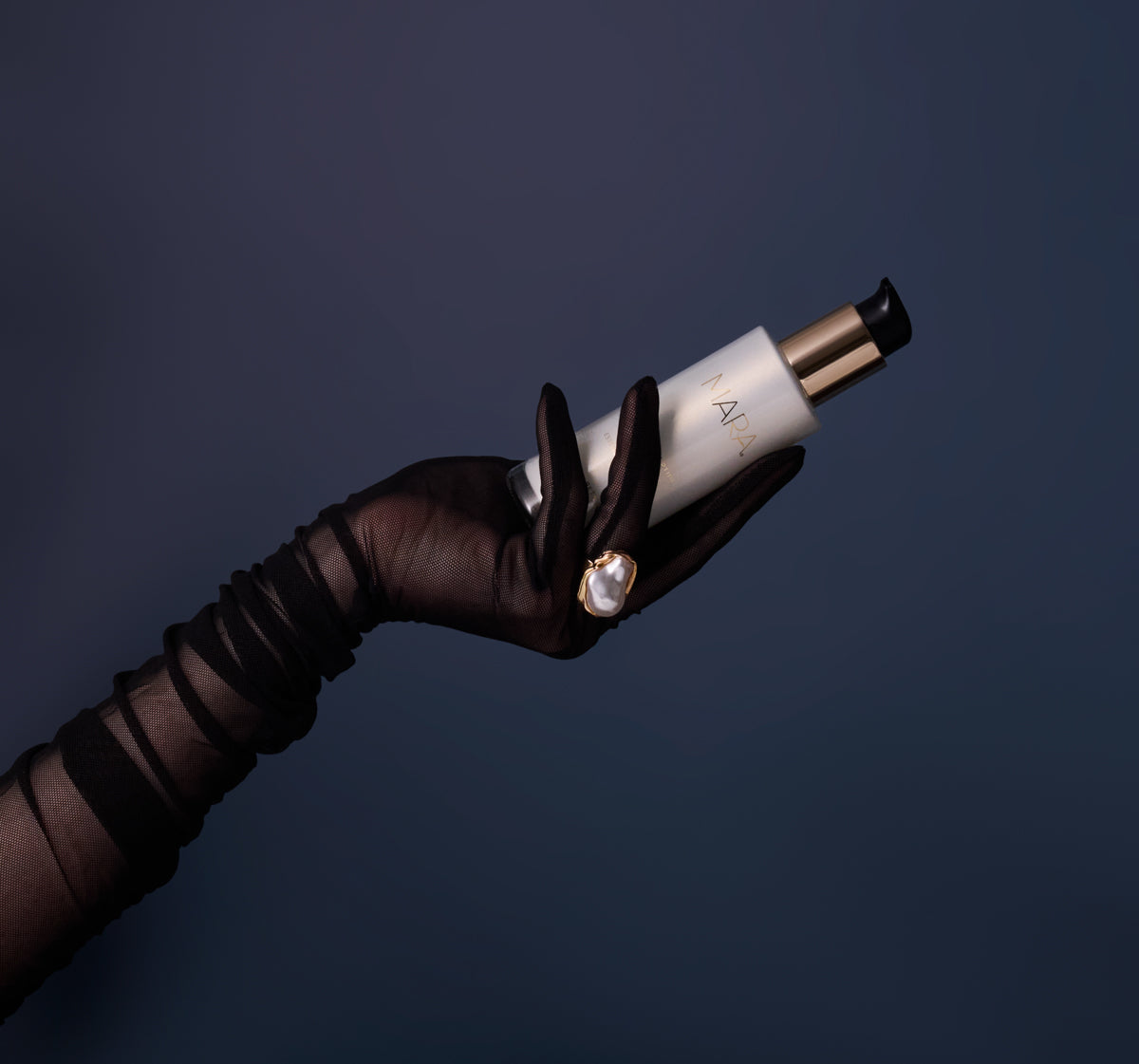 Arm and hand wearing a glove and a ring holding Pearl Peptide