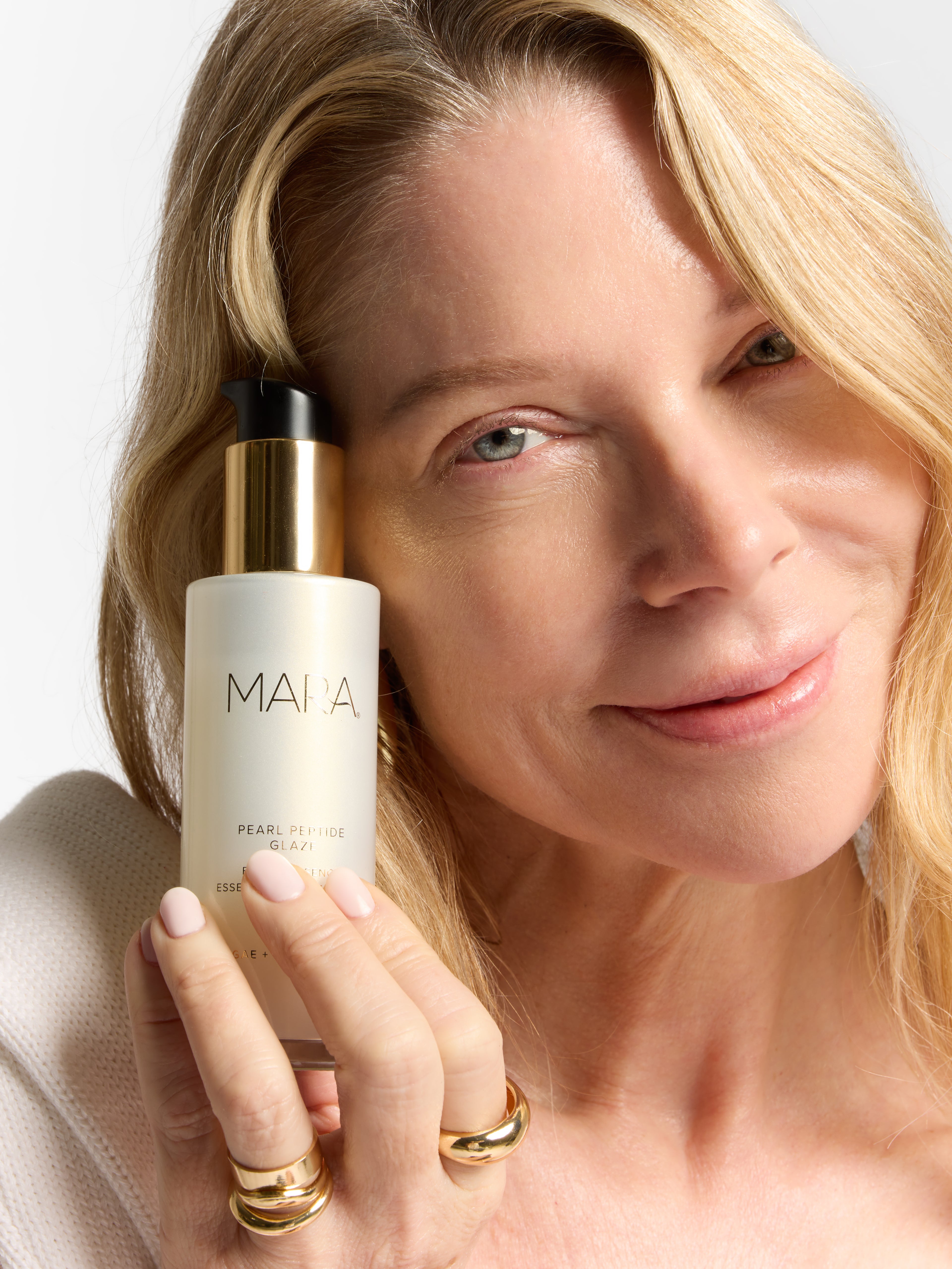 Model holding pearl peptide bottle to her cheek