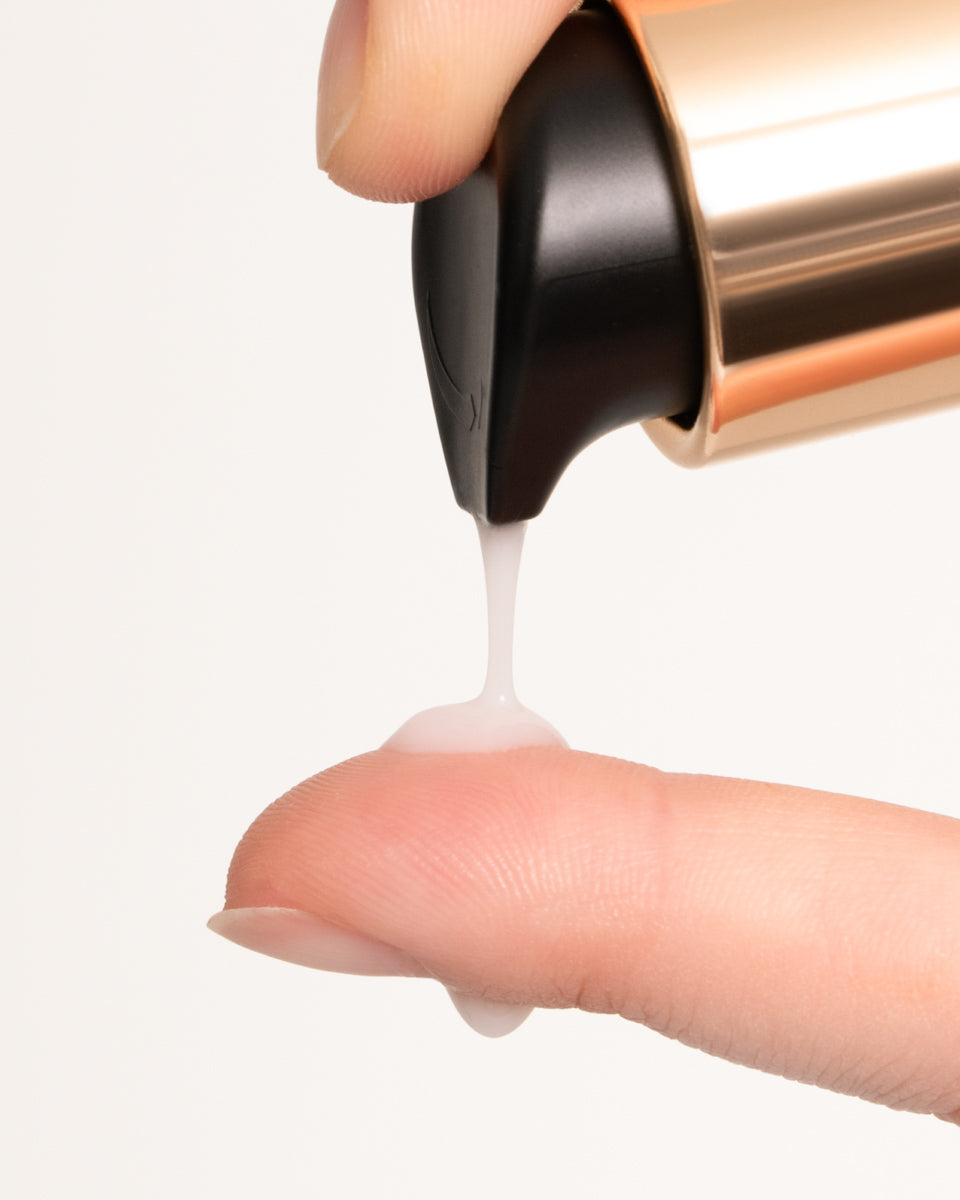 Close up of finger applying Pearl Peptide onto other finger 