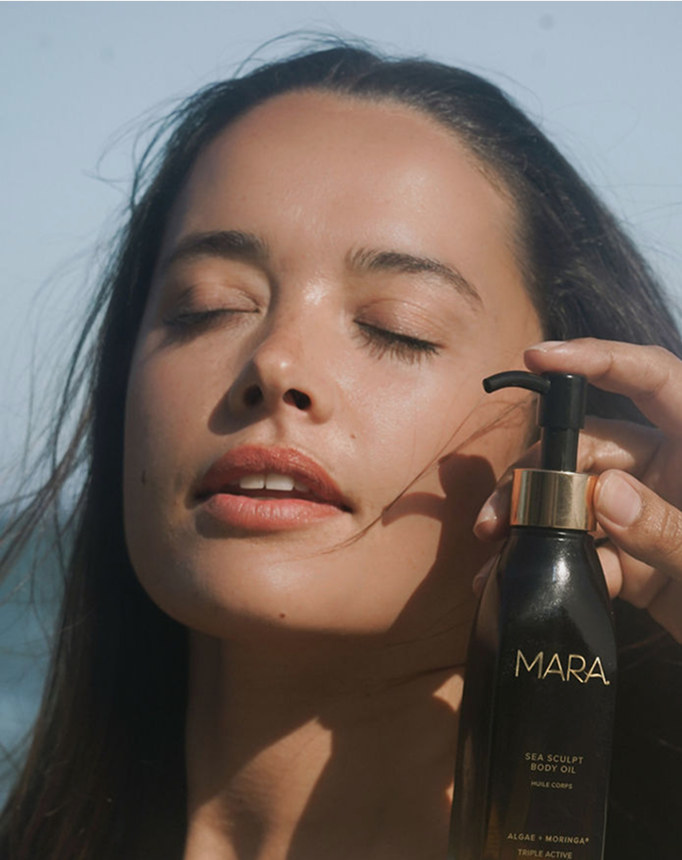 person holding Sea Sculpt Body Oil near face