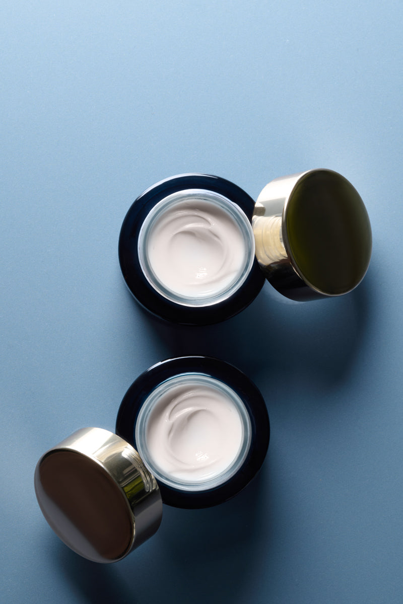 Two open jars of SeaDream Algae Creme on a blue background