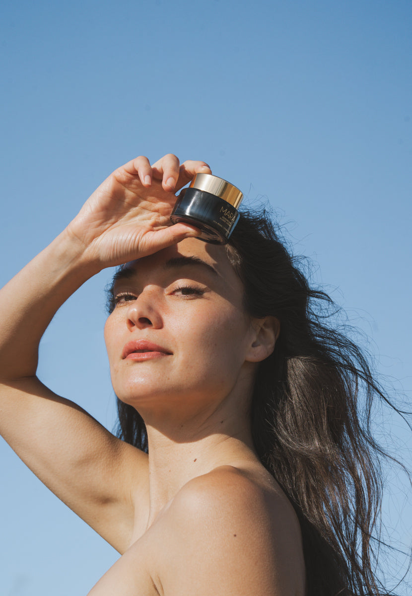 woman holding SeaDream Algae Creme in front of face