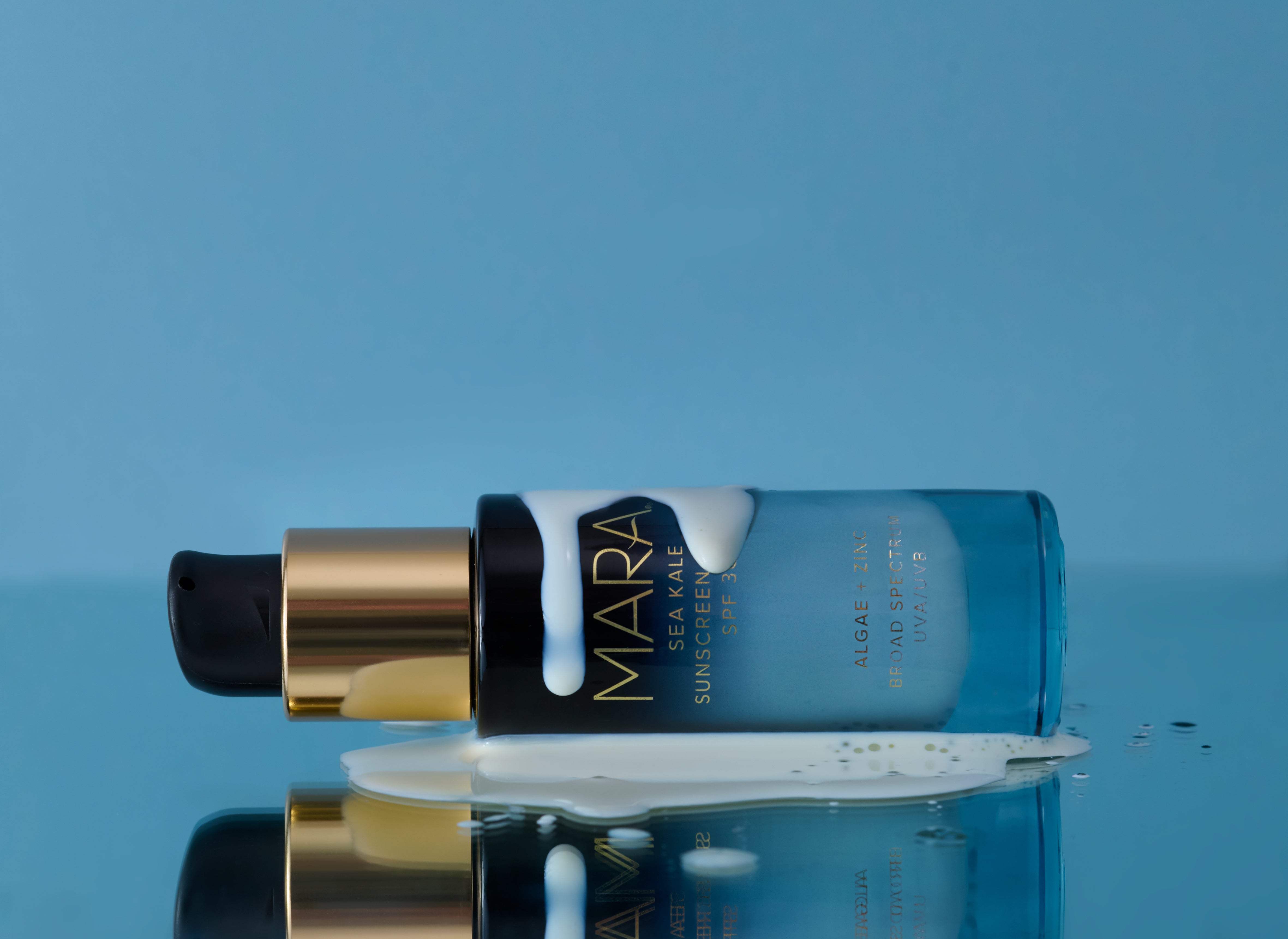 Sea Kale Sunscreen Serum with product laying down on blue surface