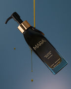 Body oil dripping onto Sea Sculpt Body Oil on blue background