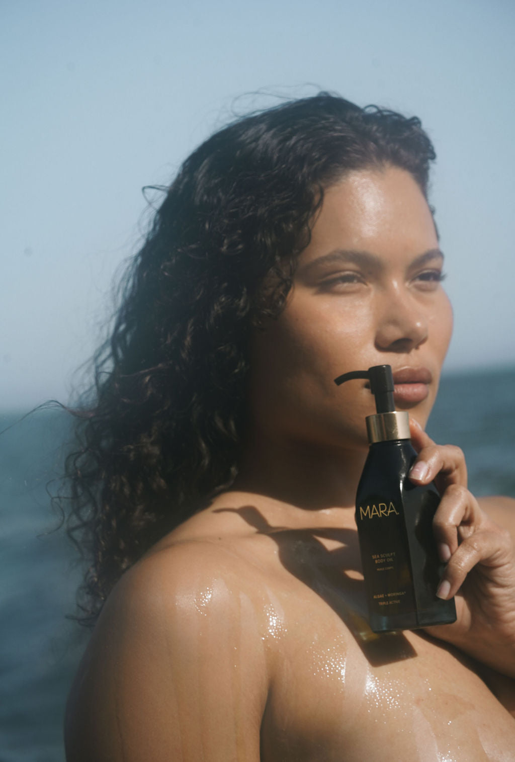 Model with Sea Sculpt Body Oil at the ocean