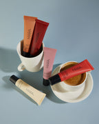 MARA Sea Silk lip balm on blue background with coffee