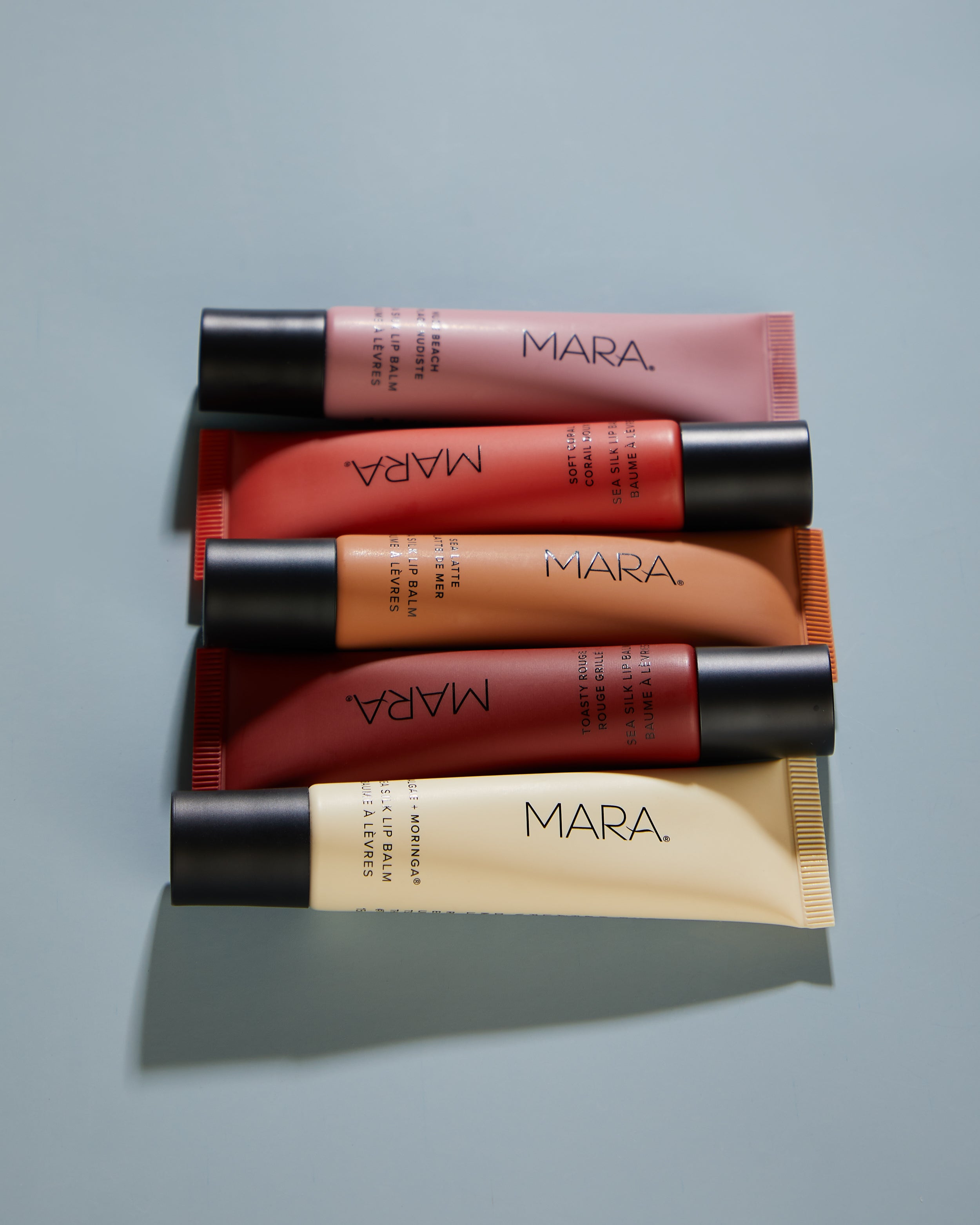 five shades of Sea Silk LIp Balm on blue surface