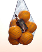 Sea Vitamin C Serum and oranges in a netted bag