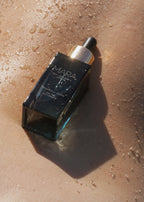 Sea Vitamin C Serum on a close up shot of a back with water and sand