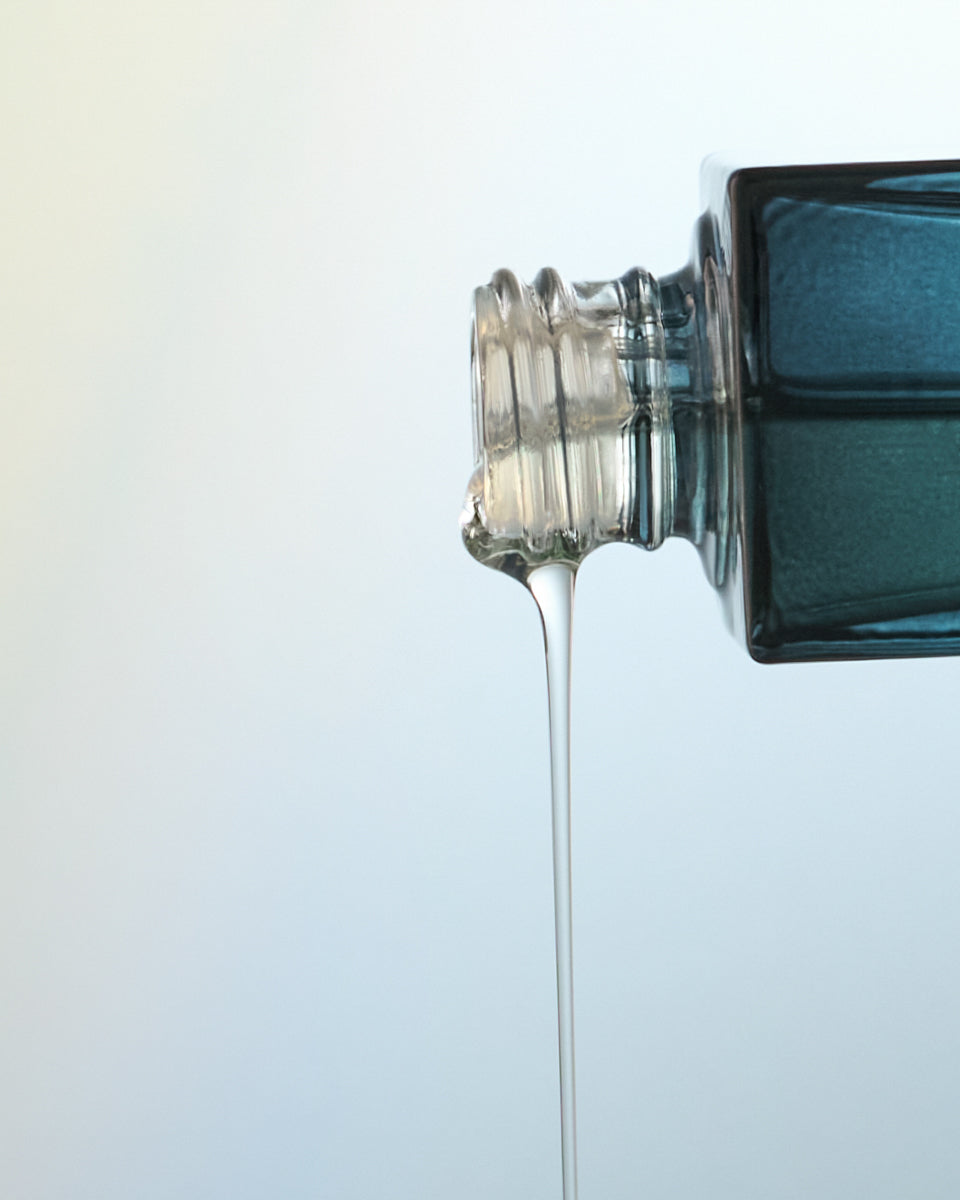Close-up of Sea Vitamin C Serum spiling out on a light blue gradient background