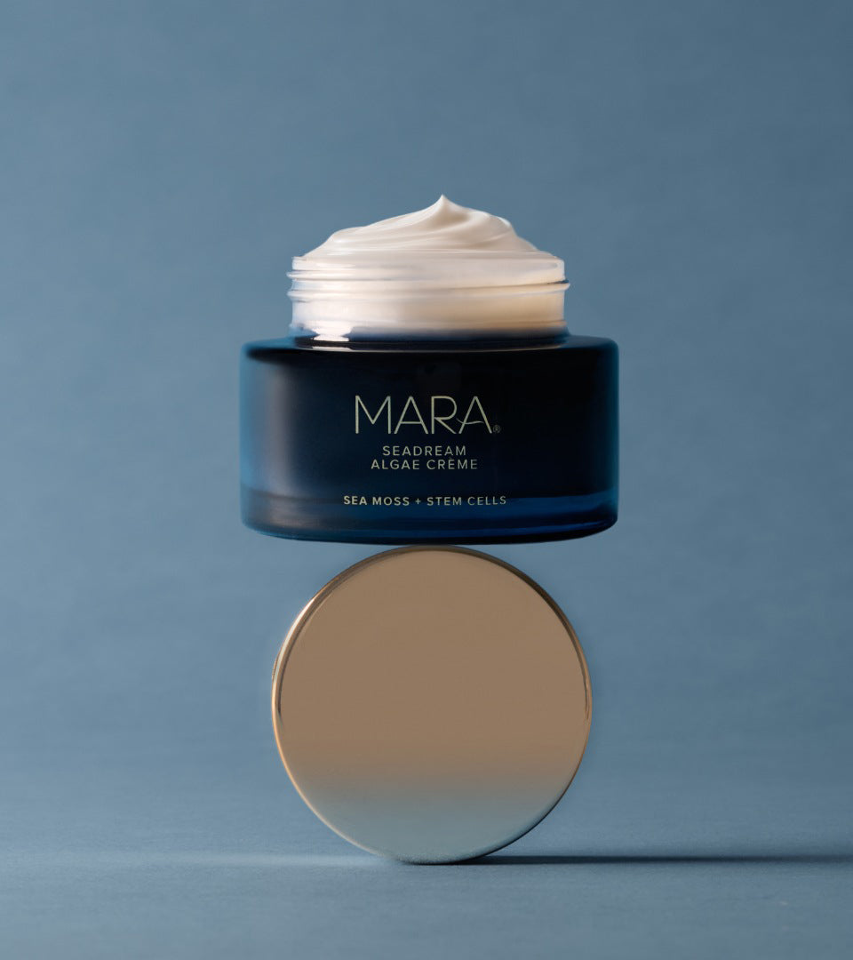 Open jar of SeaDream balancing on lid on blue background