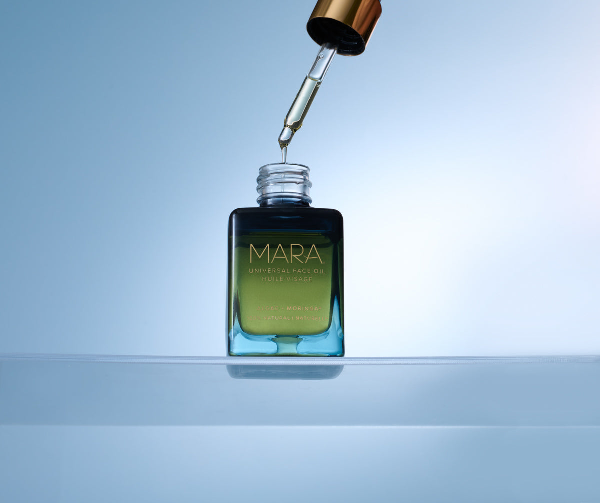 Universal Face Oil with dropper on a light blue background