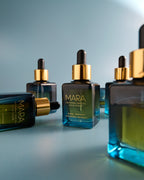 multiple bottles of Universal Face Oil on blue background