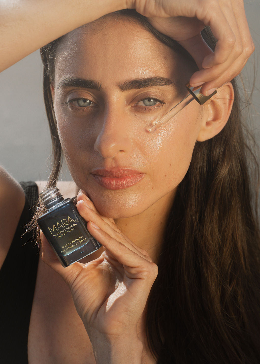 person applying Universal Face Oil 