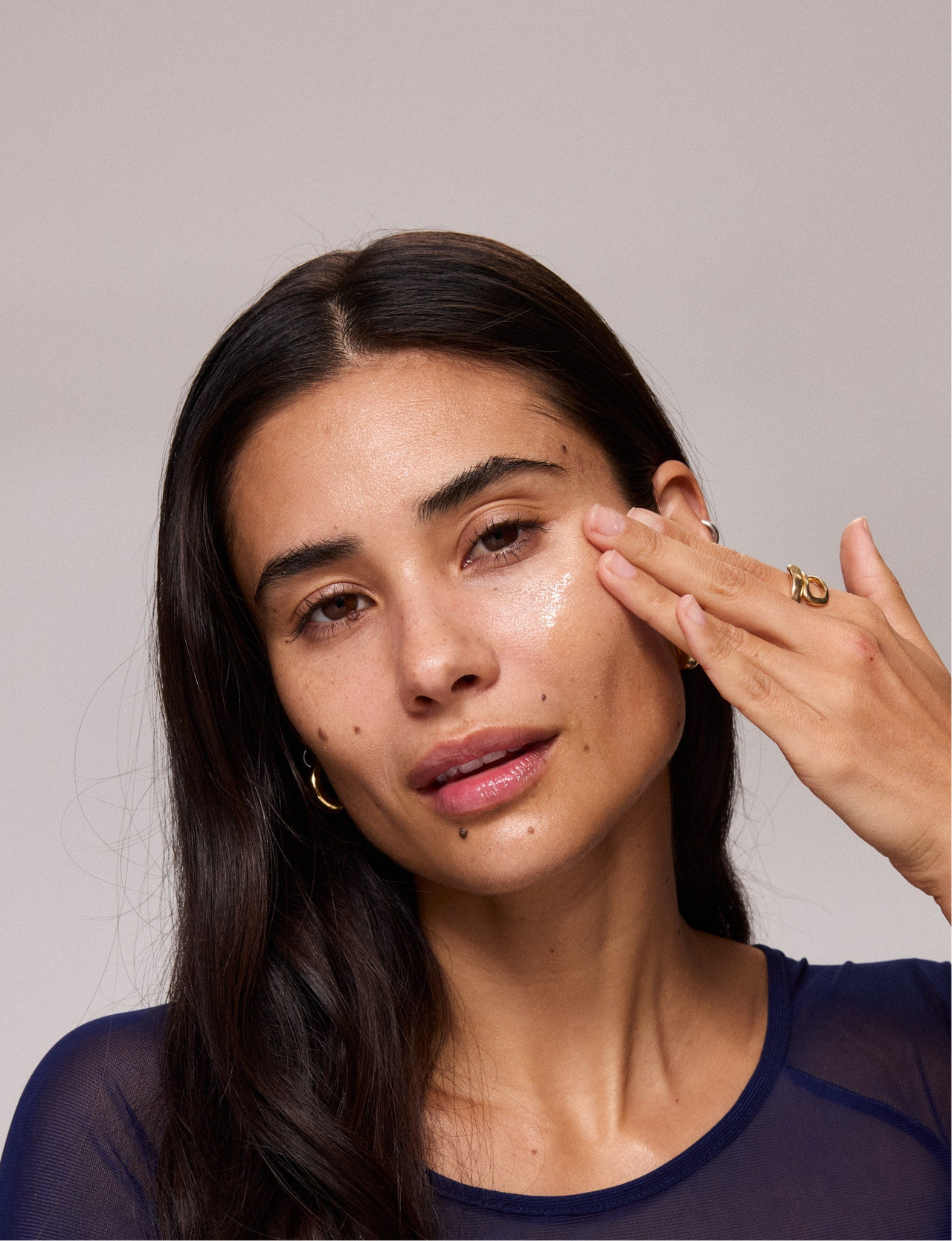 woman applying Universal Face Oil to face