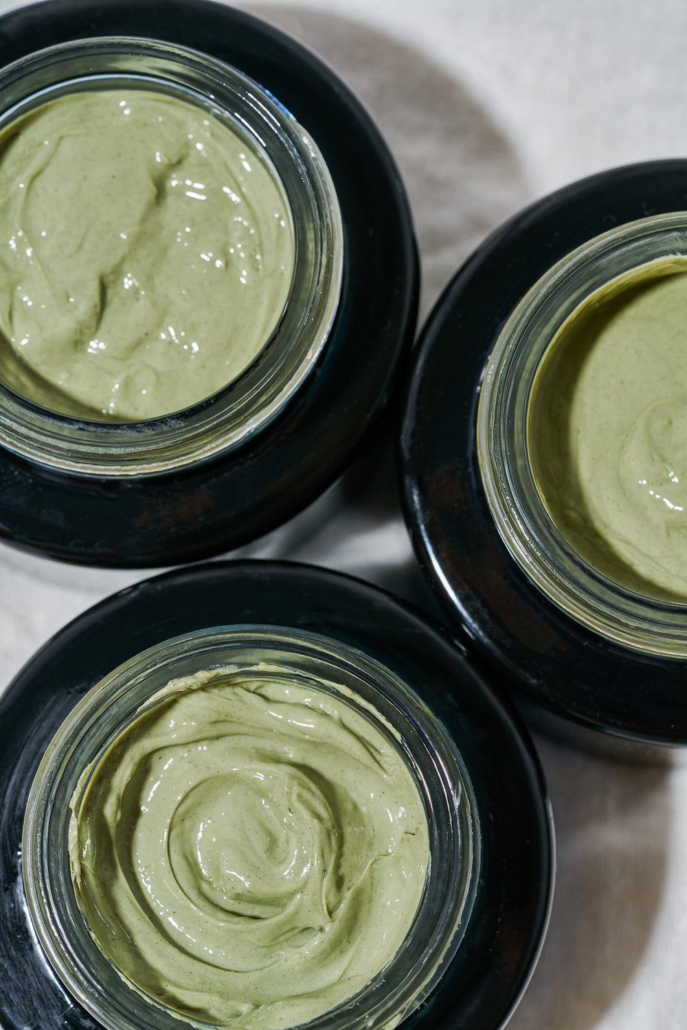 three open jars of Volcanic Sea Clay Detox Masque