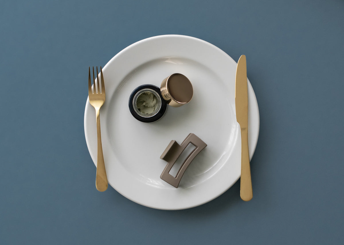 Volcanic Sea Clay Detox Masque and claw clip on a plate